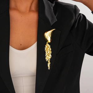 Golden fringe brooch with geometric fluid design on a black professional blazer