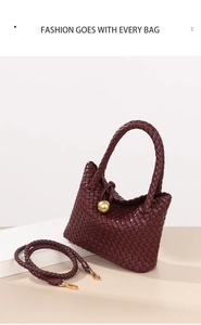 Detailansicht der burgunderroten geflochtenen Ledertasche mit schicker goldener Kugel.