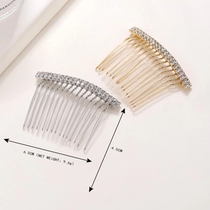 Detailed size view of silver and gold rhinestone hair combs on white stone surface