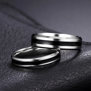 Polished stainless steel couple ring set with black enamel inlay on leather background