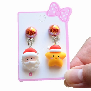 Detail view of cute Santa and yellow star clip-on earrings for kids on a card