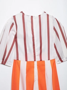 Detailed close-up of striped color-block fabric texture and stitching on the sundress
