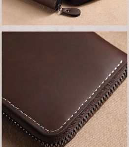 Detail of dark brown leather card holder featuring contrast white stitching and metal zipper