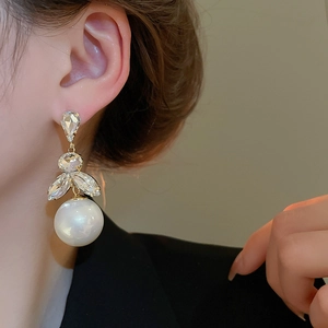 Close-up of luxury tassel pearl earring with crystal embellishment on model's ear