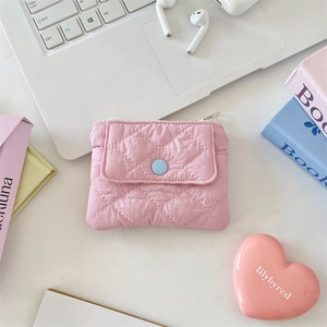 Detailed macro view of pink quilted coin purse with snap button pocket and zipper