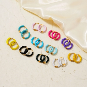 Colorful enamel hoop earrings in multiple shades on an elegant marble surface