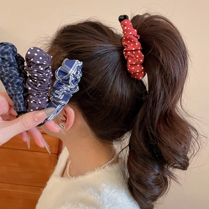 Gros plan d'une femme portant une pince à cheveux en tissu à pois rouges en queue de cheval