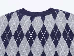 Detail of argyle knit sweater neckline with navy blue ribbed collar and precise stitching