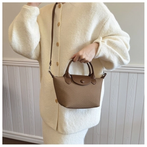 Detail view of woven brown mini tote bag styled on model for elegant daily use