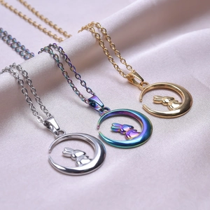 Three elegant moon rabbit necklaces in gold, silver, and iridescent finishes on pink satin