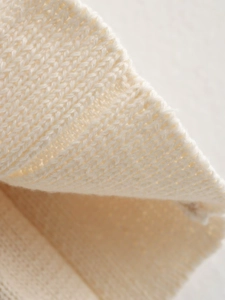 Macro view of creamy white ribbed knit texture showing soft and thick material details