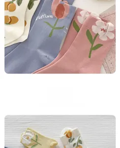 Dettaglio dei motivi floreali in maglia su calze di cotone rosa e blu pastello