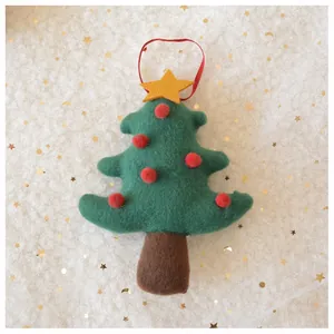 Detail of felt Christmas tree ornament with plush red balls and golden star hanging decor