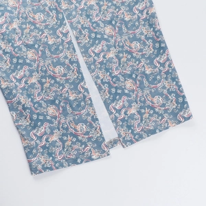 Détail de l'ourlet de robe à fleurs gris-bleu montrant des coutures propres et une fente