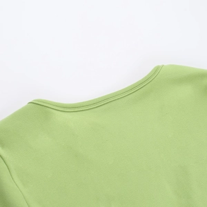 Détail du décolleté en V vert herbe montrant la texture du tricot et les finitions soignées