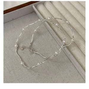 Detailed view of S925 sterling silver curved tubes and freshwater pearl bracelet set