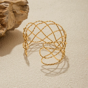 Detailed shot of a 18K gold stainless steel open cuff with irregular hammered mesh texture