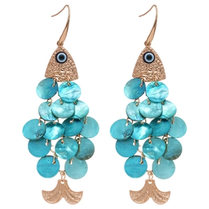 Golden fish hook earrings with blue shell scales and evil eye detail for beach vacation