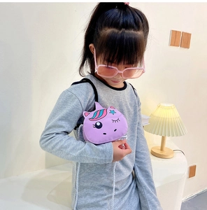 Detailed view of purple unicorn shoulder bag worn by a girl against a minimalist backdrop