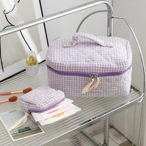 Close-up of quilted purple gingham toiletry bags with handle and zipper detail