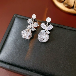 Détail de boucles d'oreilles papillon argentées avec cristaux sur écrin noir