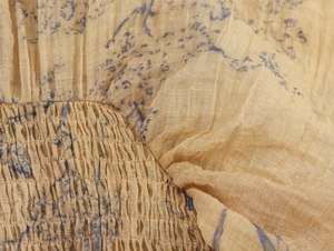 Detailed macro shot of vintage lantern sleeve fabric with blue floral print and elastic pleats