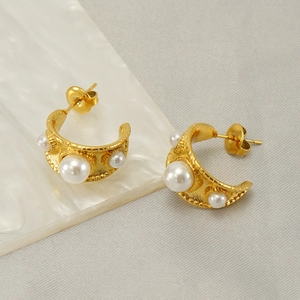 Détail des boucles d'oreilles perles dorées en C avec texture martelée vintage