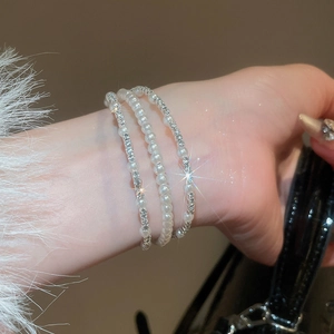 Close-up of elegant double-layer silver bracelets with pearls and sparkling rhinestones