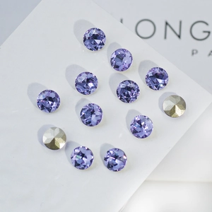 Macro detail of faceted lavender K9 crystals and gold rhinestones on display board