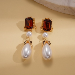 Vintage gold earrings featuring red square gems and white teardrop pearls in a pair