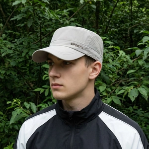 Light gray flat top sports cap with breathable laser holes shown on a model outdoors