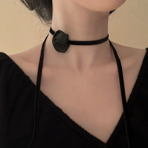 Close-up of elegant black velvet choker necklace featuring a handcrafted fabric rose detail
