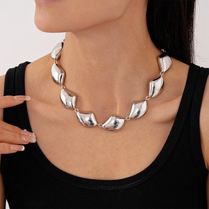 Dettaglio di una collana geometrica irregolare argento su modella con finitura in metallo lucido