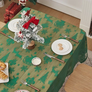 Detail der grünen Weihnachts-Spitzentischdecke mit Rentier- und Schneeflocken-Stickerei