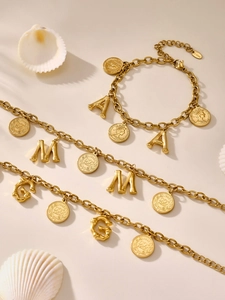Detail of 18K gold stainless steel chunky chain bracelet with Queen Elizabeth coin and charms