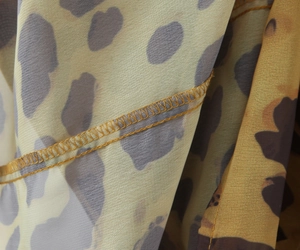 Gros plan sur tissu léopard avec coutures surjetées précises et texture mousseline
