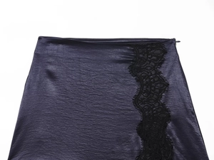 Detailed view of purple satin mini skirt featuring black eyelash lace trim and silk texture