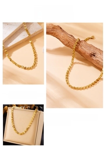 Detail view of 18K gold plated stainless steel phoenix chain necklace on various textures