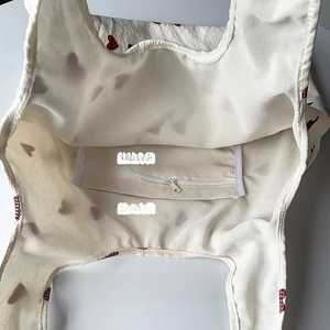 Interior view of heart print canvas bag showing zipper pocket and open slot