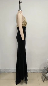 Détail de la robe de soirée fendue avec velours noir et empiècement en cuir doré à la taille