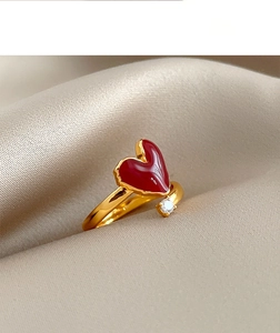 Macro detail of 18k gold plated open ring with red enamel heart and zircon stone