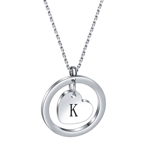 Macro detail of stainless steel necklace with engraved initial K on heart charm