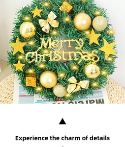Détail d'une couronne de Noël avec boules dorées, étoiles et lumières LED chaleureuses