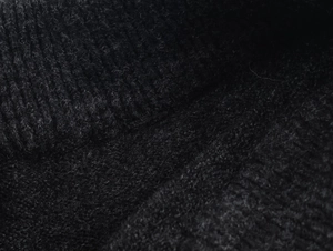 Makro-Detail von schwarzem Rippstrick mit weicher gebürsteter Textur und vertikalem Muster
