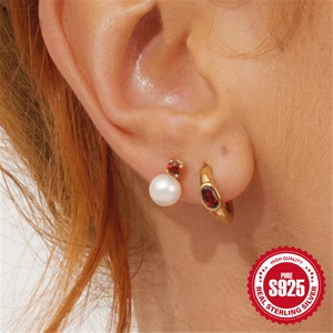 Elegant S925 sterling silver pearl earrings with red zircon accents on a female model
