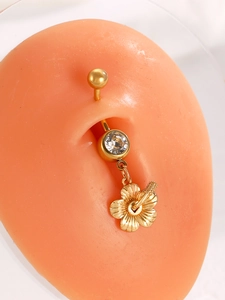 Detail of golden hibiscus flower belly button ring with sparkling crystal on silicone model