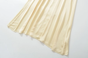 Detailansicht des beigen Satin-Kleidsaums mit glatter Textur und elegantem Fall