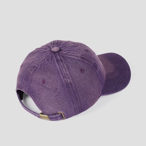 Détail d'une casquette en coton lavé violet vintage avec boucle en laiton réglable