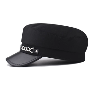 Détail d'une casquette militaire noire avec visière en similicuir et chaîne en métal argenté