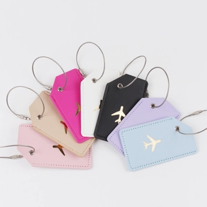 Detailed fan layout of seven colorful faux leather luggage tags with gold plane icons